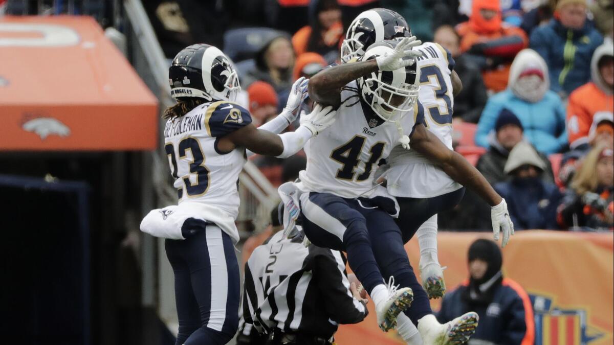 Rams strong safety John Johnson (43) celebrates his interception with defensive backs Nickell Robey-Coleman (23) and Marqui Christian (41) in the second half against the Broncos.