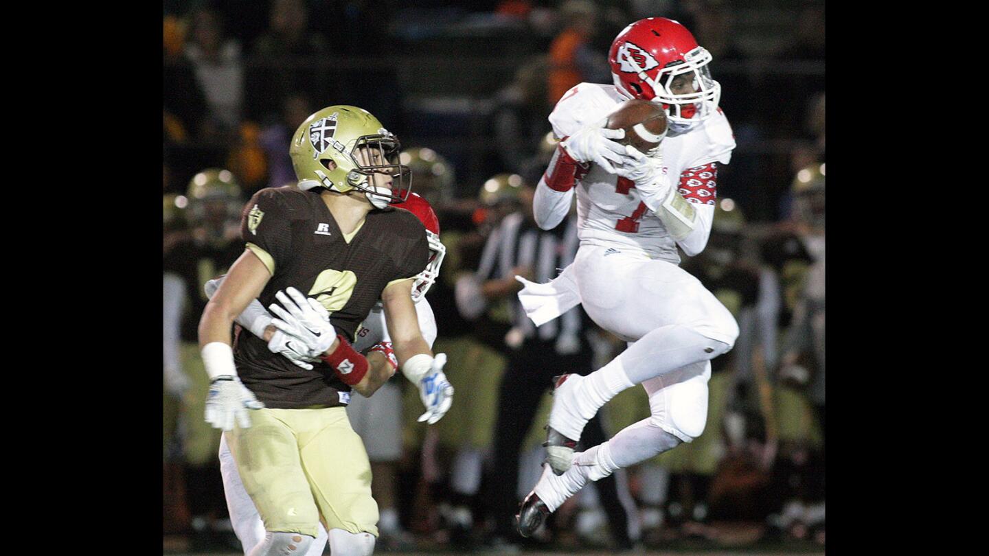 Burroughs' Robert Awunganyi jumps high to intercept the football from St. Francis' Jerry Calderon in a CIF Southern Section playoff football game at St. Francis High School on Friday, November 20, 2015.