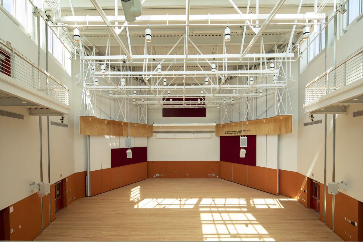 A view of an empty performance hall with sunlight streaming from a skylight above
