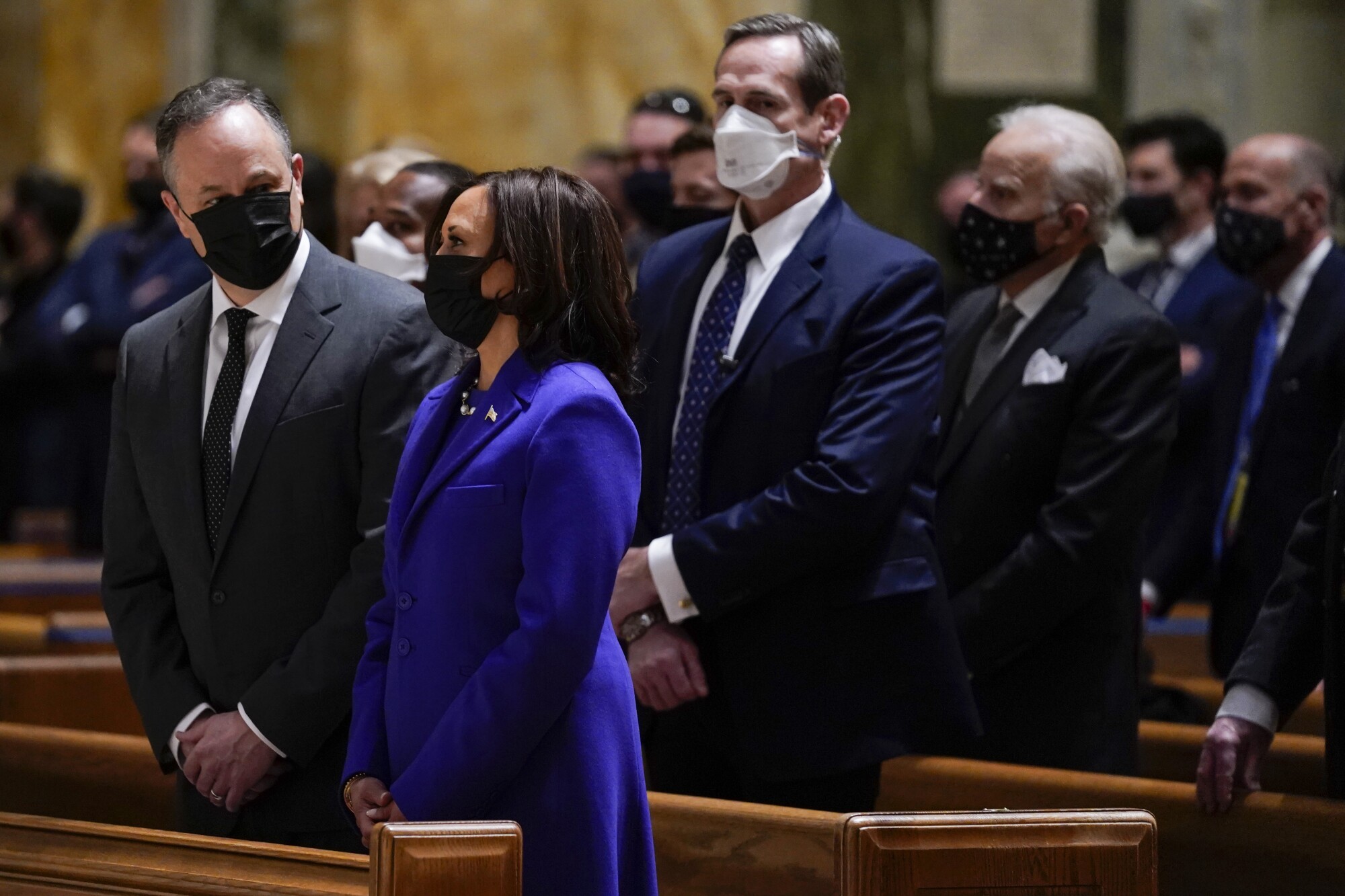 Kamala Harris and her husband, Doug Emhoff, stand in a pew at Mass at the Cathedral of St. Matthew the Apostle.