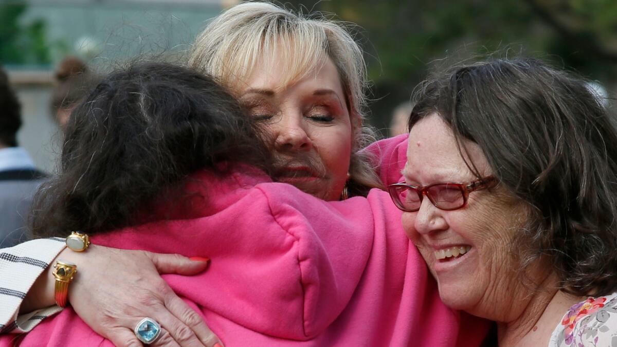 Oklahoma Gov. Mary Fallin, center, embraces Vickie Lykins, left, and Angela Richerson at a ceremony in Oklahoma City. Lykins and Richerson lost their mother, Norma Jean Johnson, in the federal building bombing.