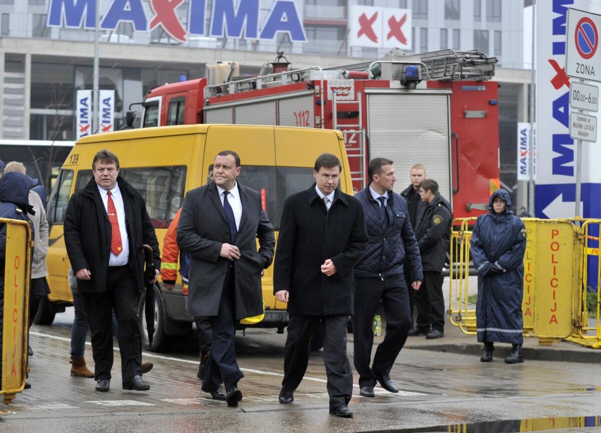 Latvian Prime Minister Valdis Dombrovskis, front center, visits a collapsed supermarket in the capital, Riga, last week.