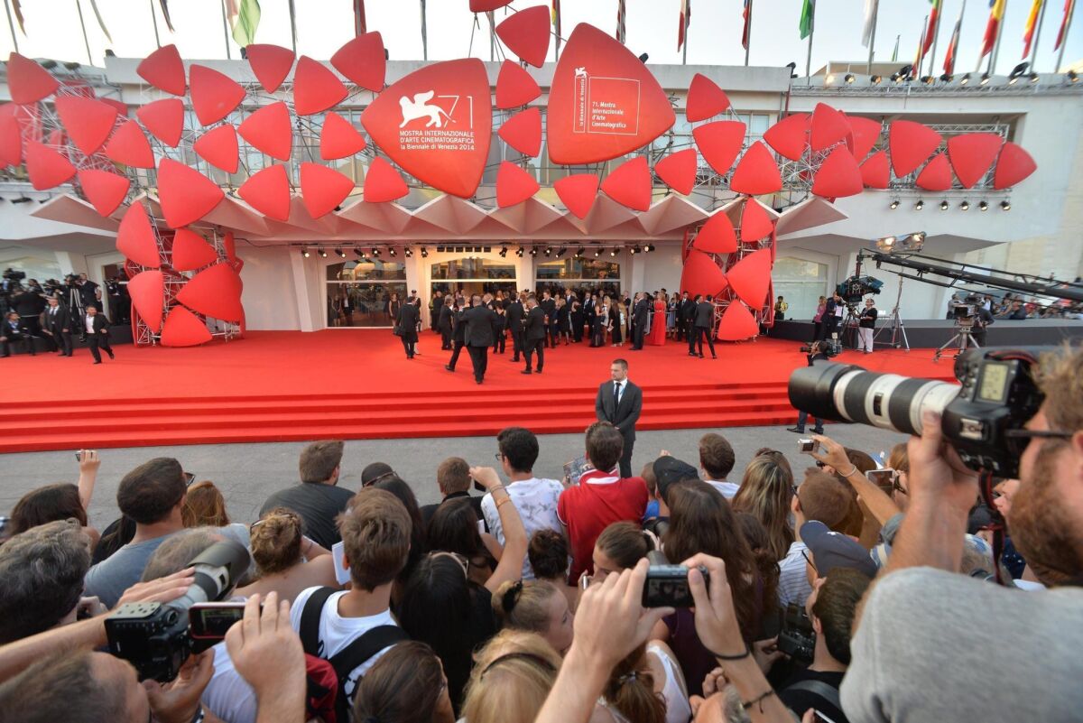 People wait to glimpse the stars arriving for the opening ceremony and screening of "Birdman or (The Unexpected Virtue of Ignorance)" at the 71st edition of the Venice International Film Festival, in Venice, Italy, in 2014.