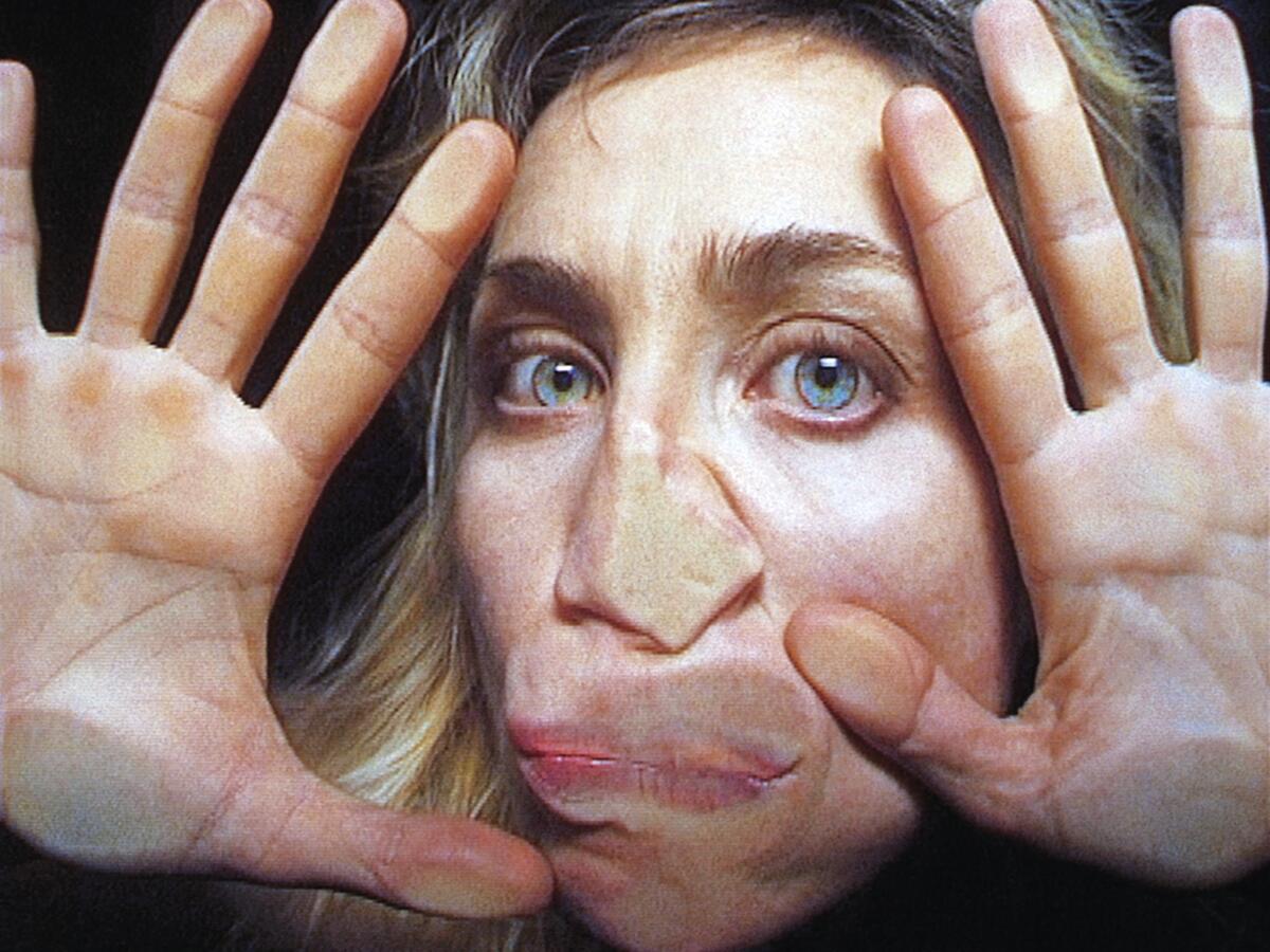An image from Pipilotti Rist's  2000 video "Open My Glade": A woman's face and hands face the camera, pressed up to glass