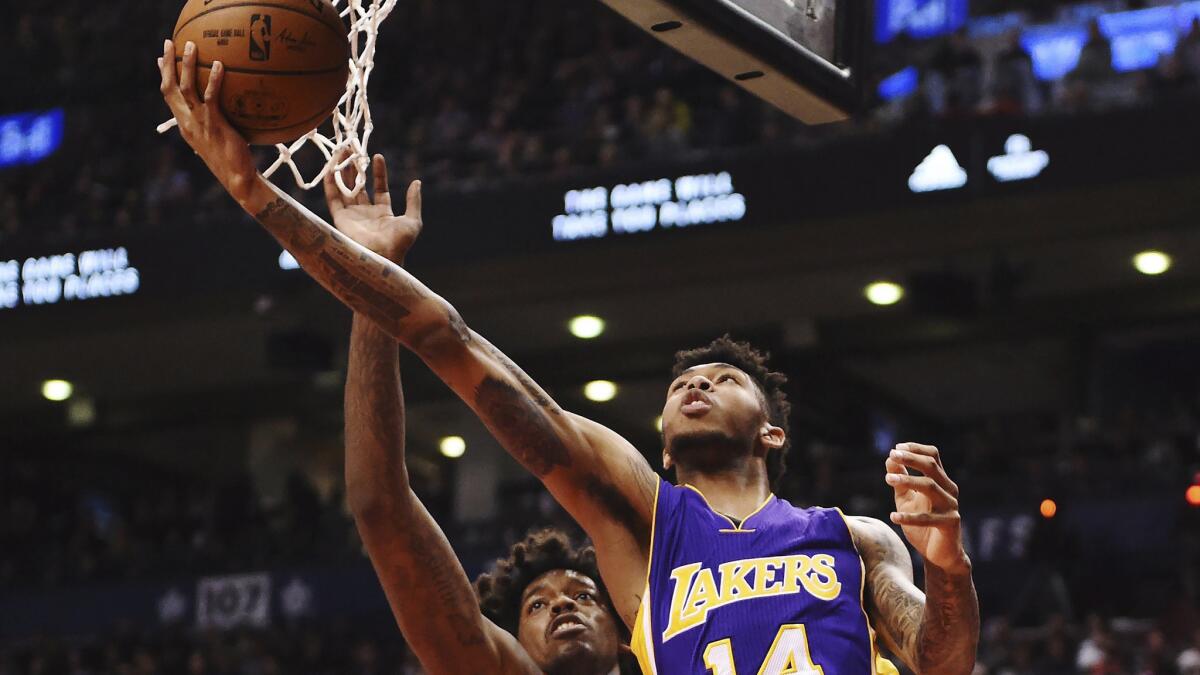 Lakers forward Brandon Ingram scores on a reverse layup against Raptors center Lucas Nogueira during the first half Friday night in Toronto.