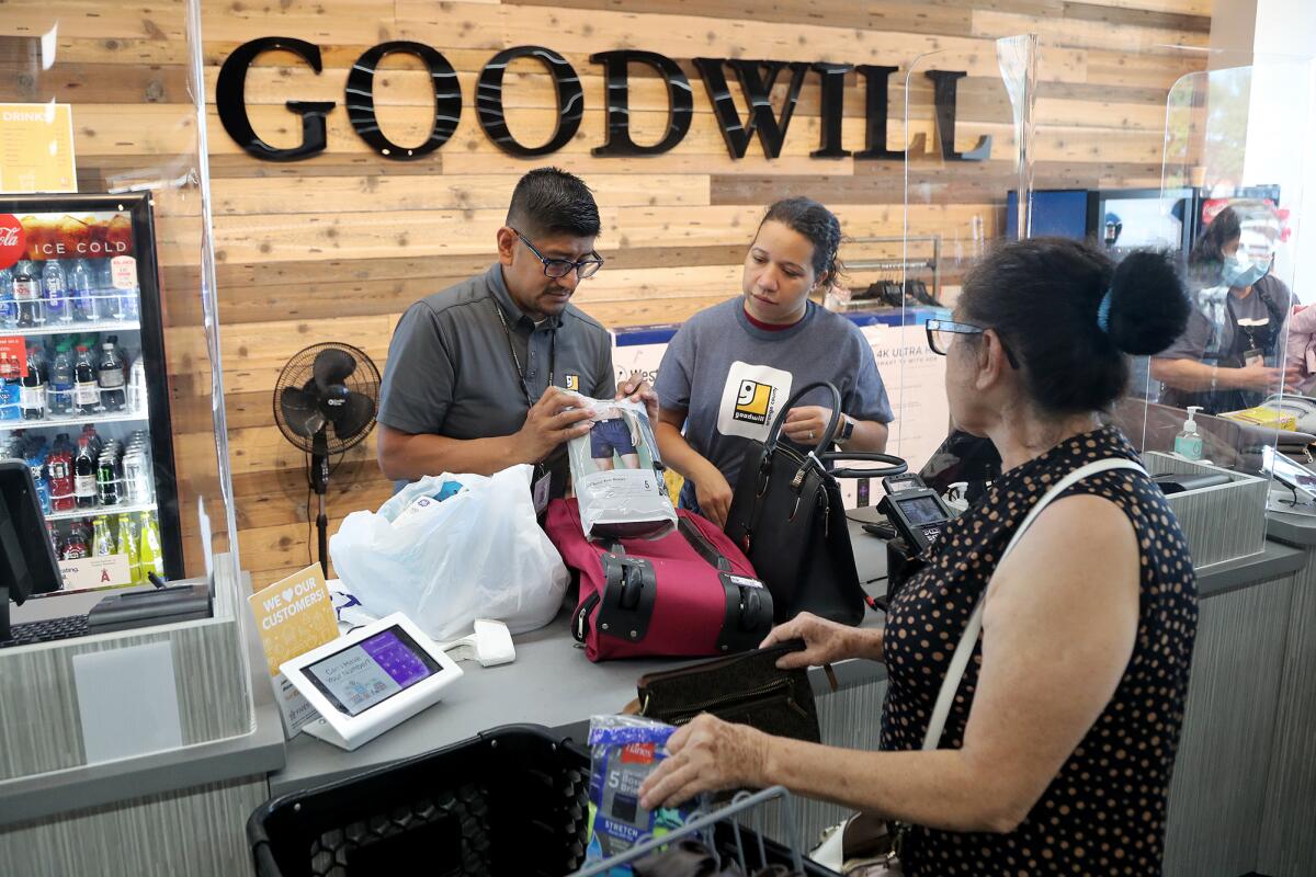 Employees ring up a customer's items during the grand reopening for Goodwill Orange County.