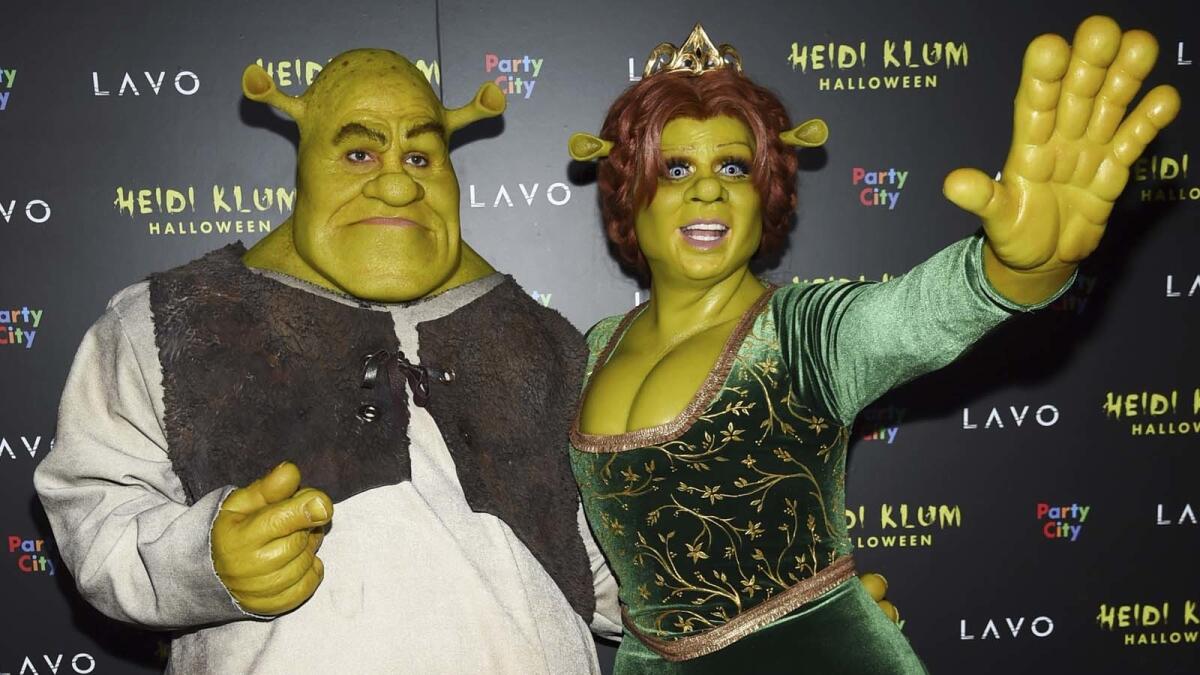 Heidi Klum, right, and boyfriend Tom Kaulitz dressed as ogres Princess Fiona and Shrek at her Halloween bash in New York on Wednesday.