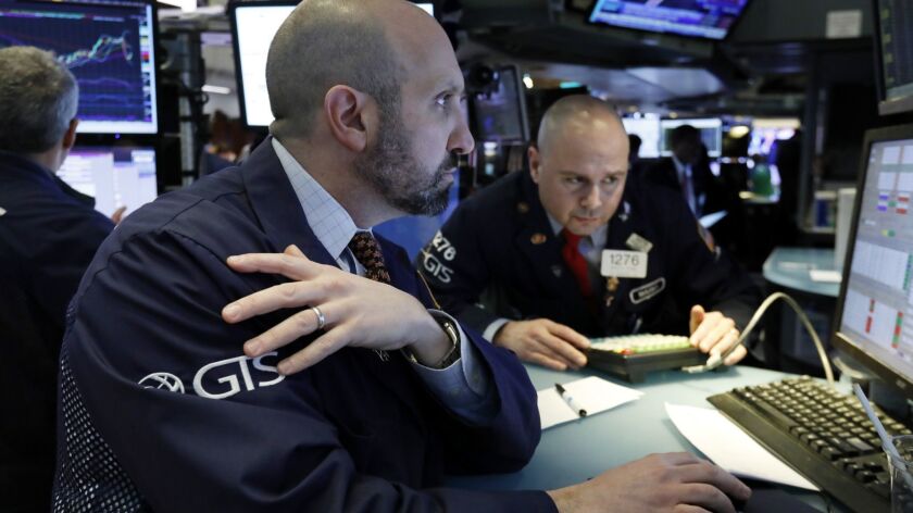Specialists James Denaro, left, and Mario Picone work at a post on the floor of the New York Stock Exchange on March 12.