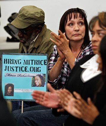 Tammy Michell of Fullerton, holding a sign in support of Mitrice Richardson, applauds a speaker during a meeting with L.A. County Sheriff Lee Baca hosted by the Compton-based National Assn. for Equal Justice in America.