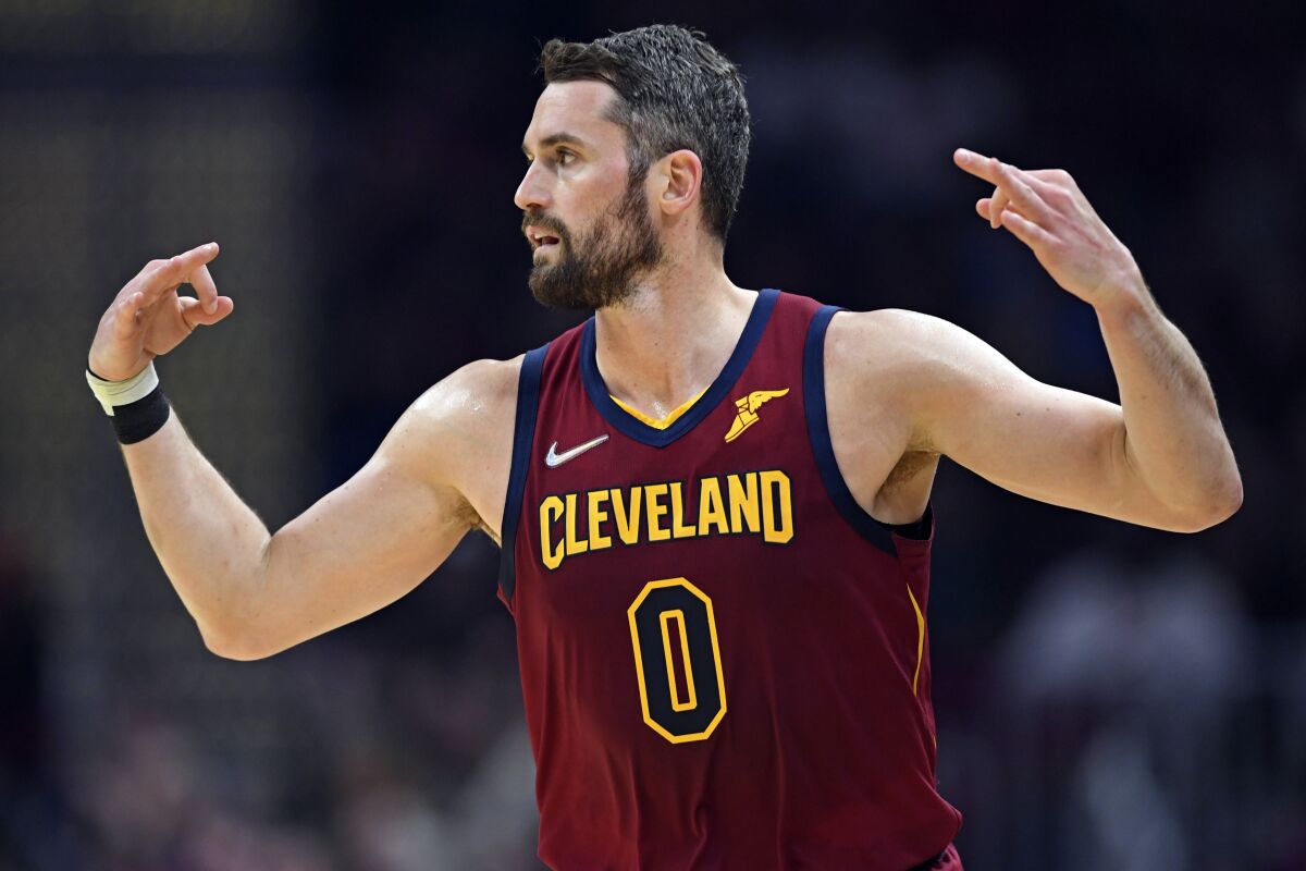 Cleveland Cavaliers forward Kevin Love celebrates after a 3-point basket in the first half of an NBA basketball game against the Milwaukee Bucks, Sunday, April 10, 2022, in Cleveland. (AP Photo/David Dermer)