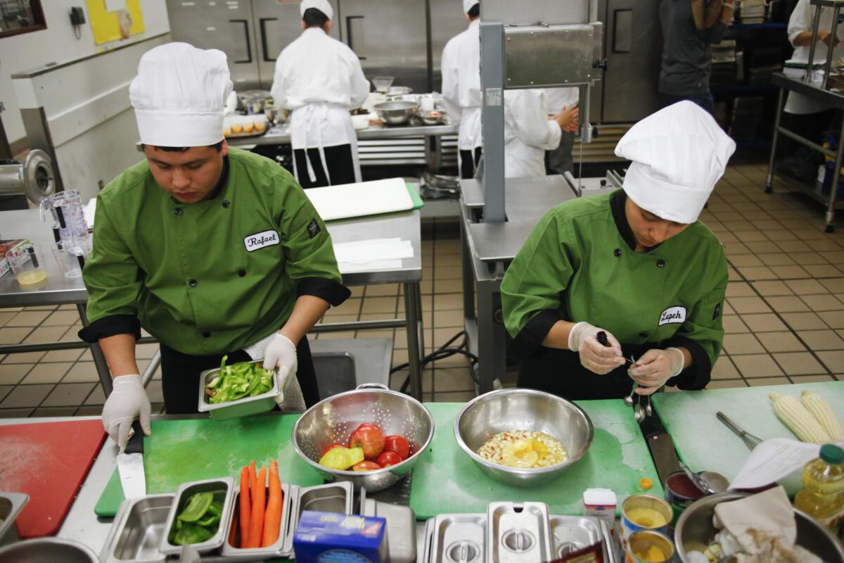 Rafael Alvirde, left, and Guadalupe Francisco from Santee Educational Complex prepare ingredients for their healthy "Viva Tamale" and "Fiesta Salad" at a Los Angeles Unified cooking contest. State officials opened applications Tuesday for a $250-million grant program to connect academic learning to career pathways.