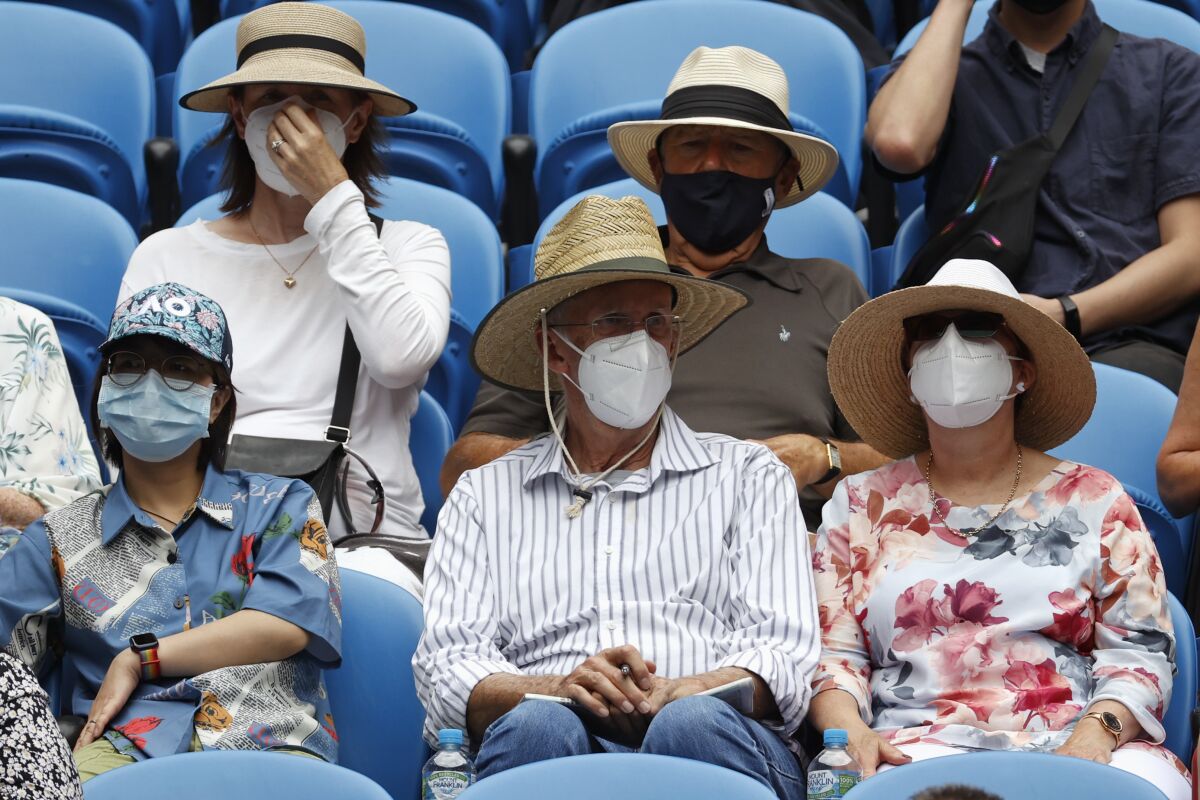 Masked spectators watch first round matches on Rod Laver Arena at the Australian Open tennis championships in Melbourne, Australia, Monday, Jan. 17, 2022. (AP Photo/Hamish Blair)