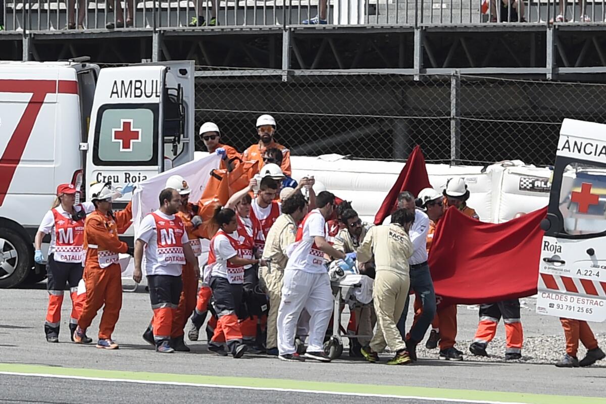 Luis Salom is treated by medics Friday after crashing at the Catalunya racetrack in Montmelo, near Barcelona. (Josep Lago / AFP/Getty Images)
