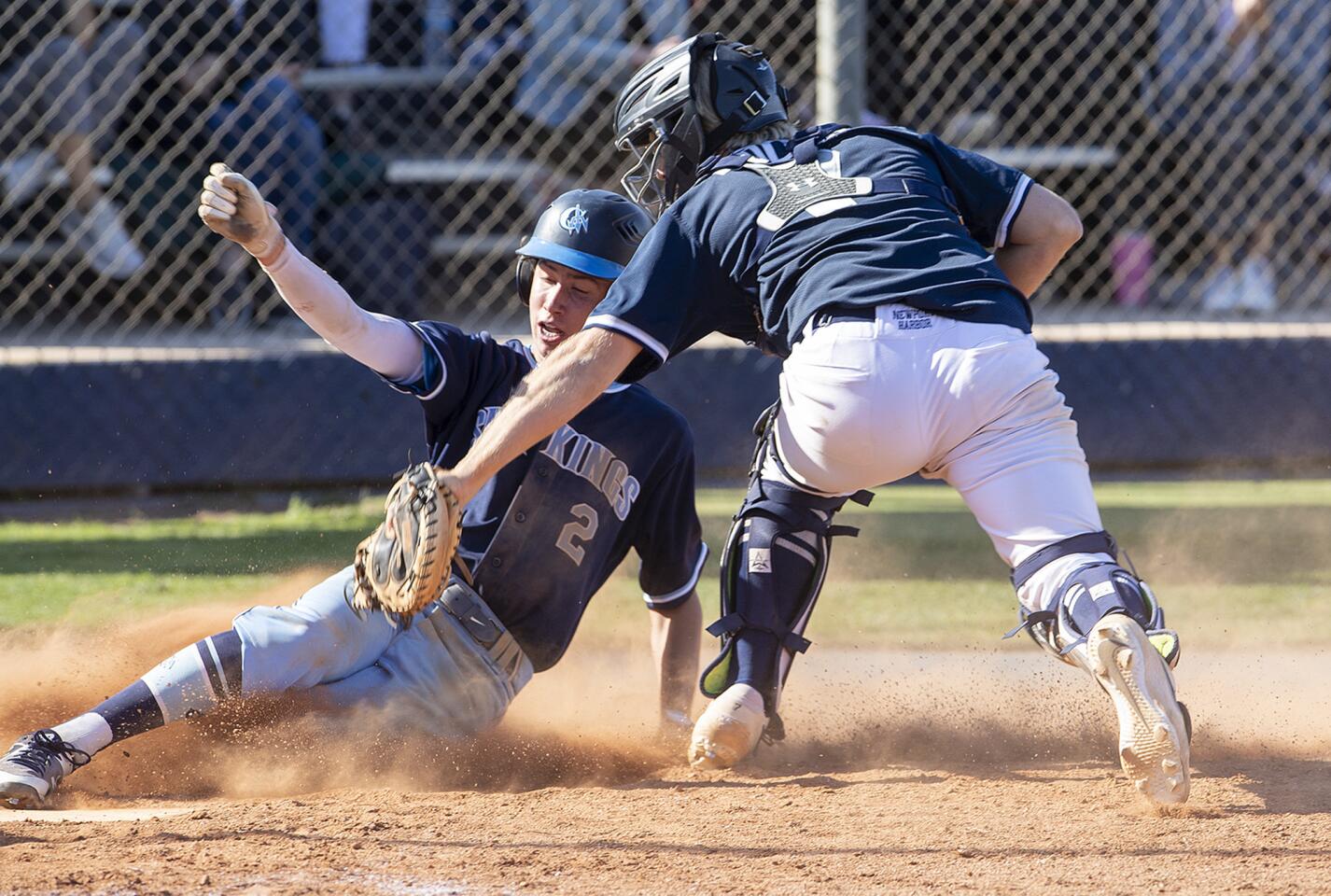 Newport Harbor's Clay Liolios makes the tag on Corona del Mar's Matthew Decrona who is called out at the plate during a Wave League game on Tuesday, April 16.