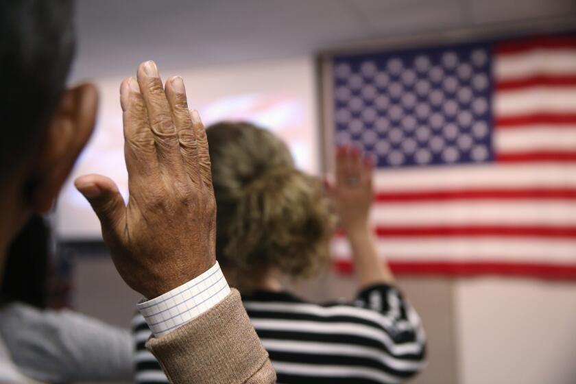 Immigrants take the oath of U.S. citizenship at a naturalization ceremony held at the U.S. Citizenship and Immigration Services office in New York City.