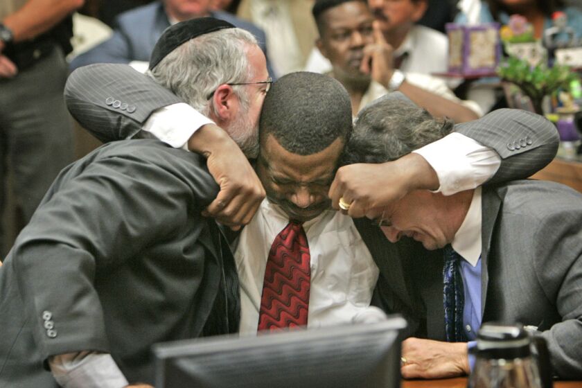 Attorney Michael Schwartz, left, is hugged by ex-deputy Ivory John Webb Jr. as he also hugs attorney William J. Hadden. Webb was acquitted in the shooting of an off-duty Air Force officer in 2007.