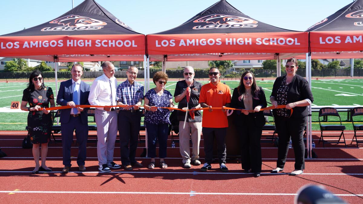 Garden Grove USD Trustee Bob Harden cuts the ribbon of athletic facilities at Los Amigos High.