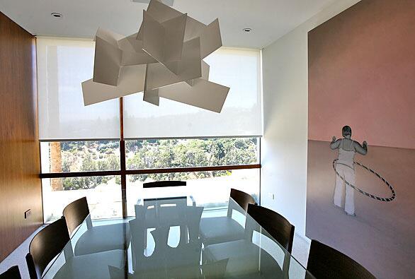 In the 8.5-foot-tall dining room of a Neutra-inspired house in Beverly Hills, architect John Bertram faced a dilemma with a picture window: "It's very hard to get glass larger than 60 square feet, so we broke it into four irregular panels with walnut mullions," he explains. The walnut-paneled wall, which has a pocket door for privacy, also required a non-standard 10-foot sheet of veneer. Uninterrupted walls and recessed doorjambs were a Neutra signature, Bertram says. Though the dining room is many more steps away from the kitchen than in most houses Bertram says, the owners don't treat it as a formal space. Full gallery