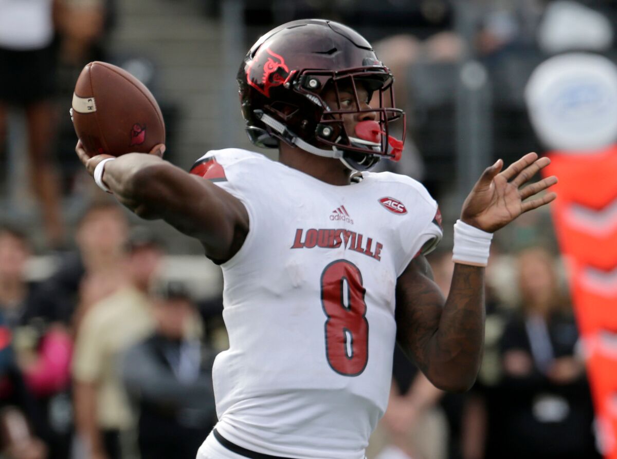 FILE - In this Oct. 28, 2017, file photo, Louisville's Lamar Jackson (8) looks to pass against Wake Forest during the second half of an NCAA college football game in Winston-Salem, N.C. Louisville will retire the No. 8 jersey number of former Cardinals quarterback Lamar Jackson, who in 2016 became the school’s first Heisman Trophy winner and finished his college football career as one of its most decorated players. Jackson’s jersey number will be retired during a ceremony at Louisville’s Nov. 13, 2021 home game against Syracuse.(AP Photo/Chuck Burton, File)