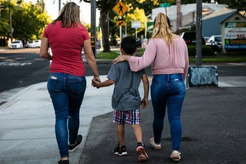 SACRAMENTO CA JULY 3, 2019 -- Maggy Krell, chief counsel of Planned Parenthood, left, and her client, "Patricia" right, walk home with her seven-year-old son, "Alessandro" from dinner in Sacramento, California, July 3, 2019. ?Patricia? and her seven-year-old son ?Alessandro? are part of a group of about eight asylum seekers who are now suing the Trump administration for emotional distress as a way to combat family separations. (Max Whittaker / For The Times)