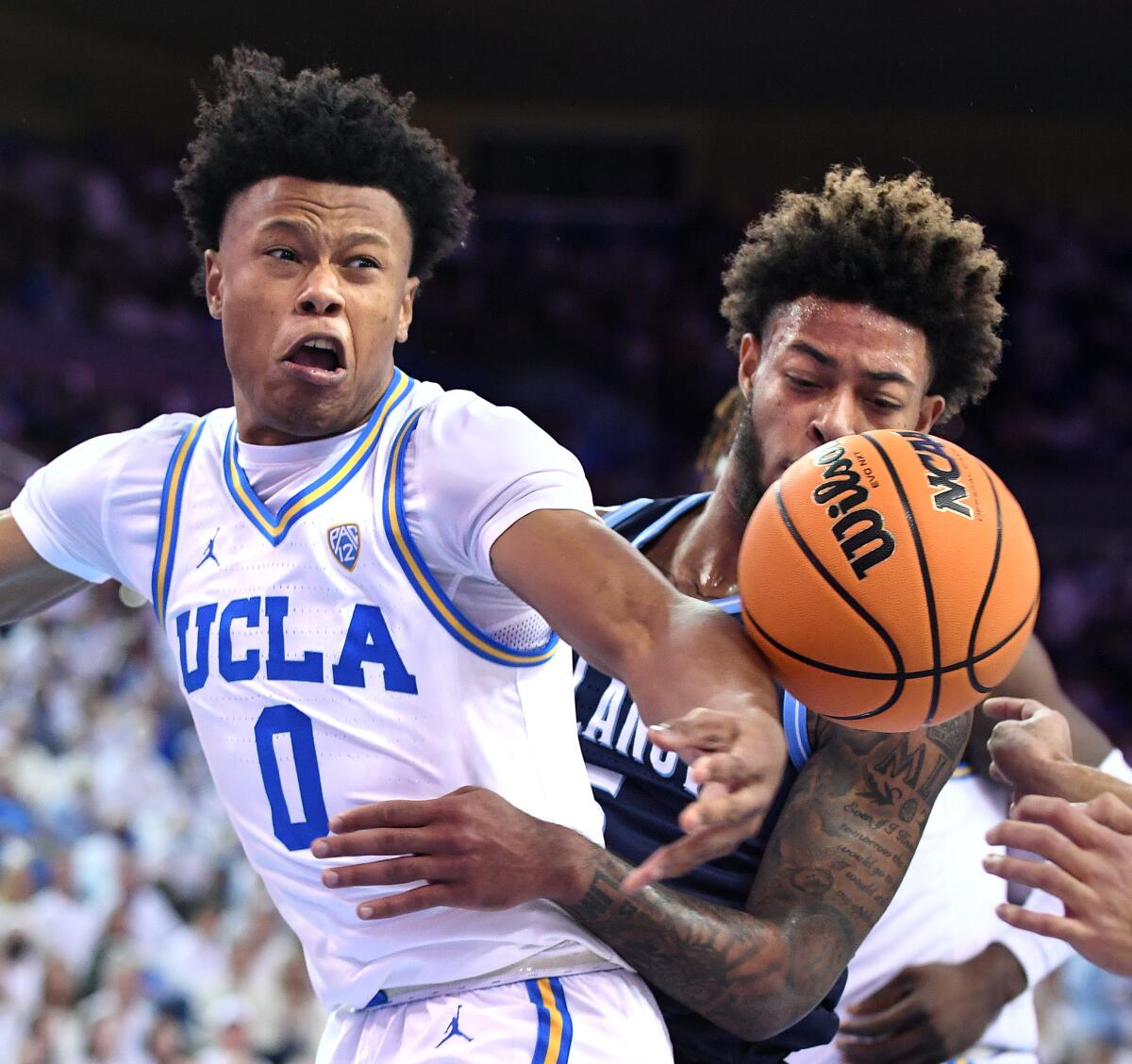 UCLA's Jaylen Clark battles Villanova's Justin Moore for a loose ball.