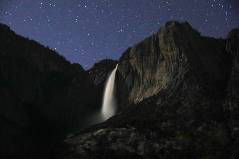YOSEMITE NATIONAL PARK—APRIL 18, 2021—Yosemite Falls and starry sky photographed Sunday night, April 18, 2021.Yosemite National Park is open at a reduced capacity, and will require reservations to drive into the park starting on May 21, 2021. (Carolyn Cole / Los Angeles Times)