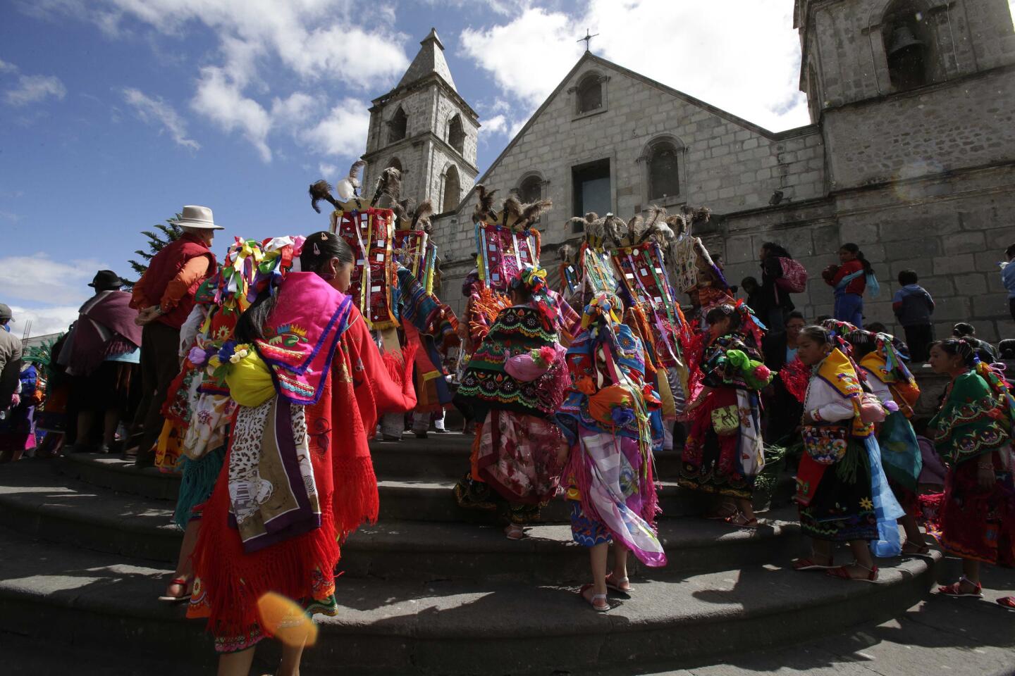 Un grupo de danzantes entra en la iglesia al comienzo de las fiestas del Corpus Christi en Pujilí, Ecuador. El sacerdote permite la entrada a los bailarines, que después actúan en honor del Dios cristiano.