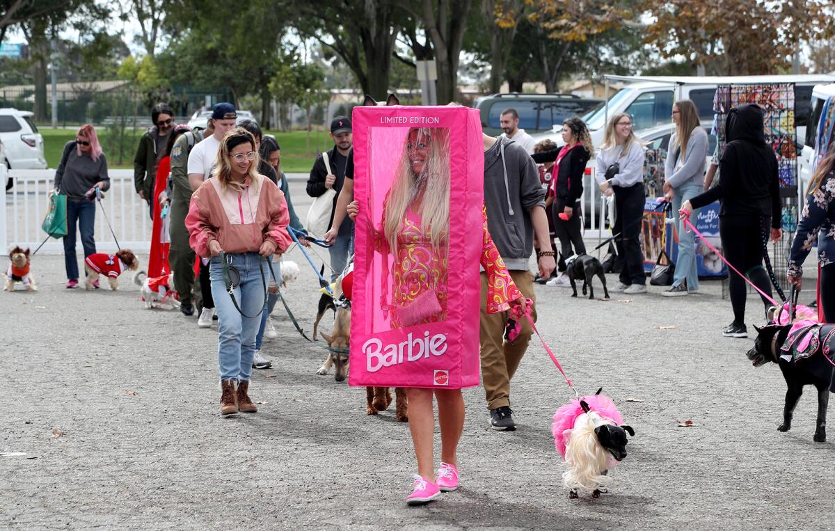 Laura Gilbert of Dana Point, dressed as a Barbie doll, walks Kiva, a Jack Russell terrier mix, Barktoberfest .