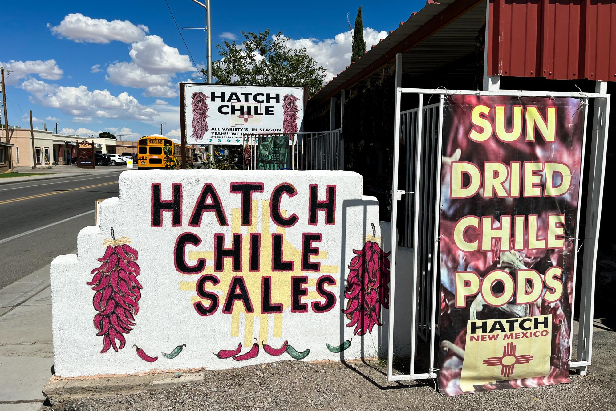 Signs for Hatch Chile Sales depict clusters of red chiles and advertise sun-dried chile pods