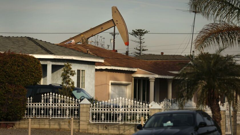 A reciprocating piston pump, commonly known as a pumpjack or rocking horse, pulls oil from the ground in a Wilmington neighborhood.