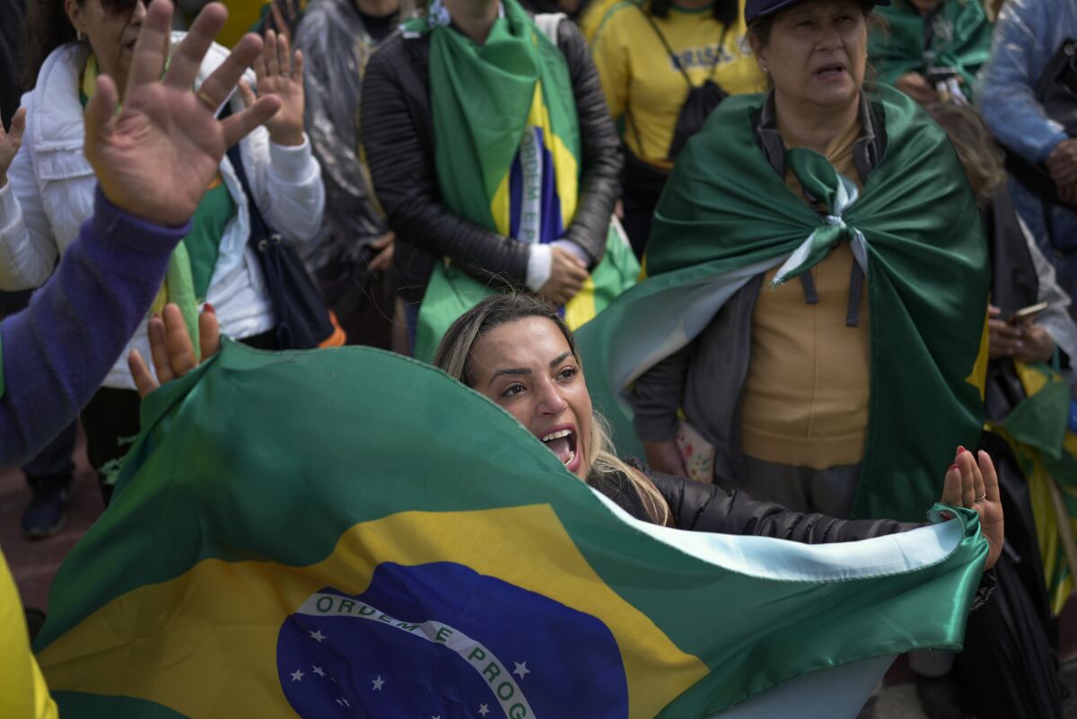 A supporter of President Jair Bolsonaro holds a Brazilian flag