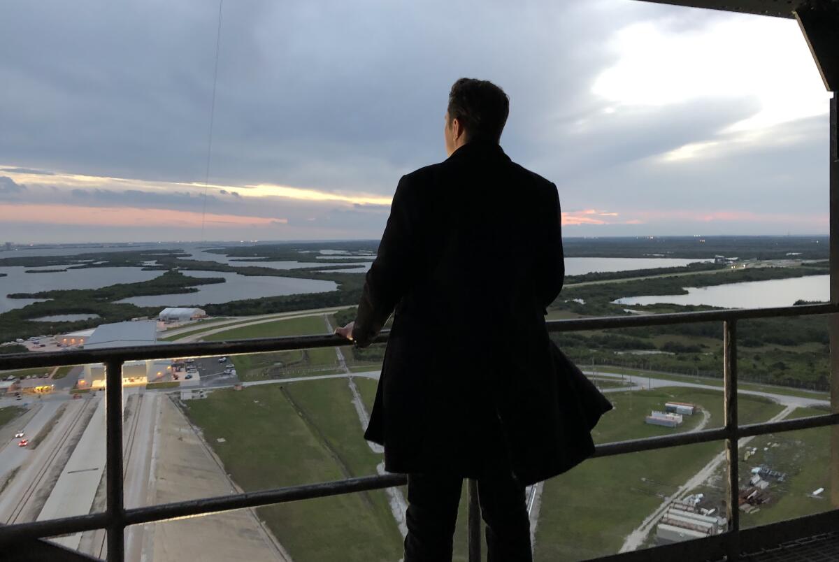 A man, seen from behind, looks out over Cape Canaveral.