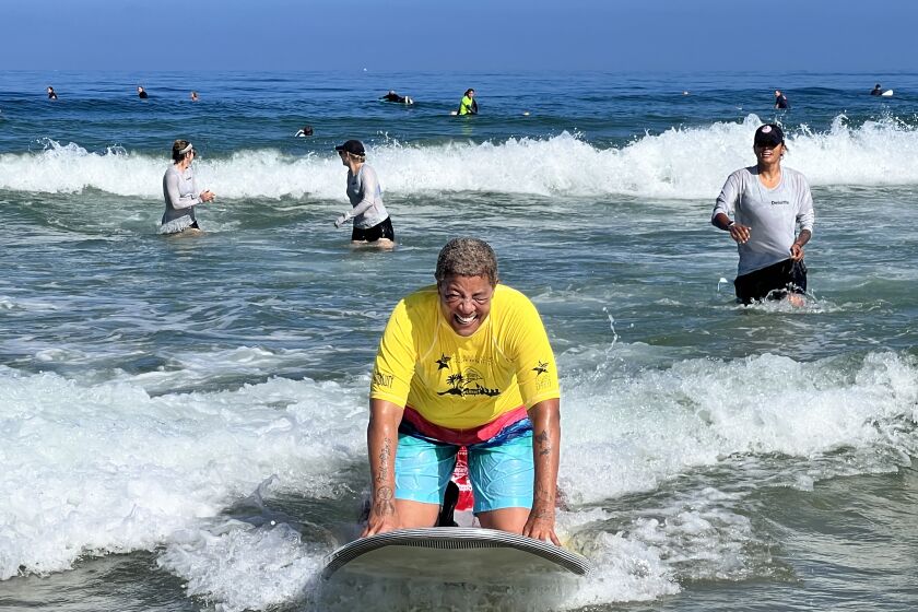 Marine veteran Michelle Bennett rides the waves during an Aug. 10 surfing session at La Jolla Shores.