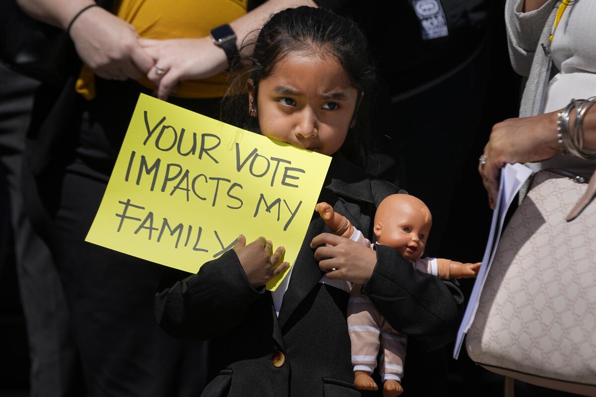 Evelyn Morales, de 6 años, sostiene un letrero durante una conferencia de prensa afuera del Capitolio 