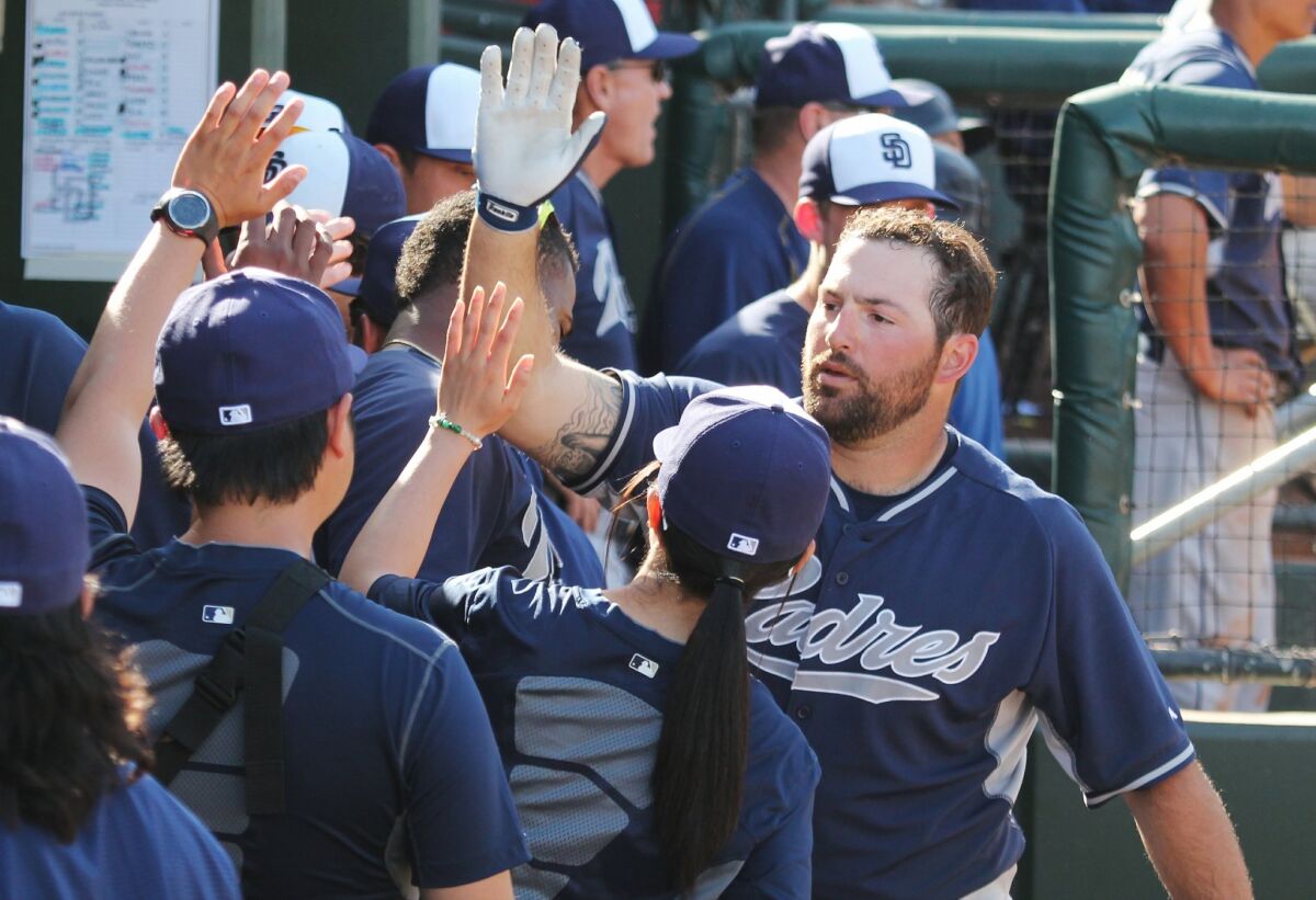 Padres infielder Cody Decker receives high fives in the dugout after hitting a home run in spring training.