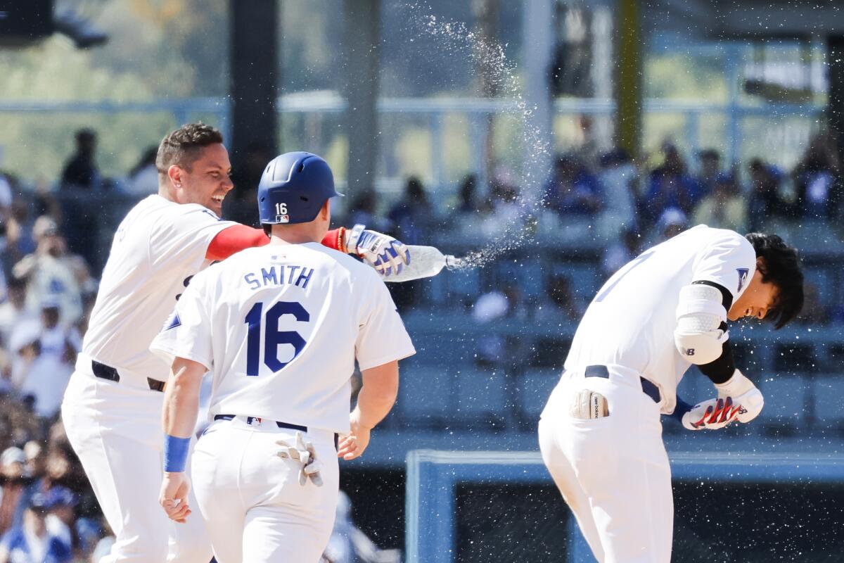 Miguel Rojas, left, throws water on Shohei Ohtani after a walk-off single. 