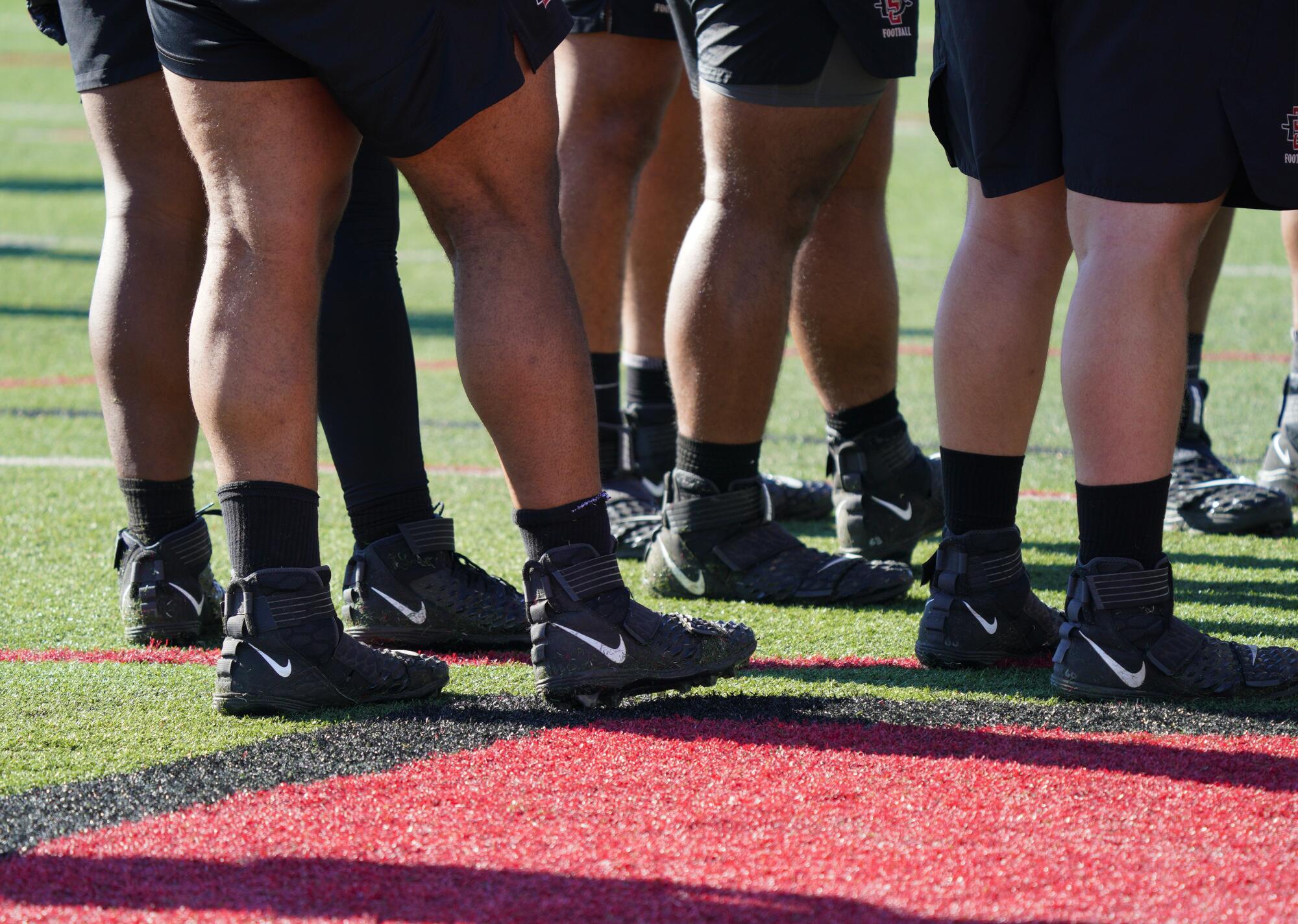 The legs of some players on the SDSU football team.