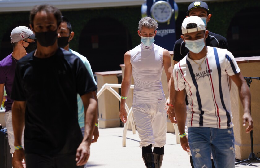 Opening day at the Del Mar Racetrack with jockeys wearing face masks.