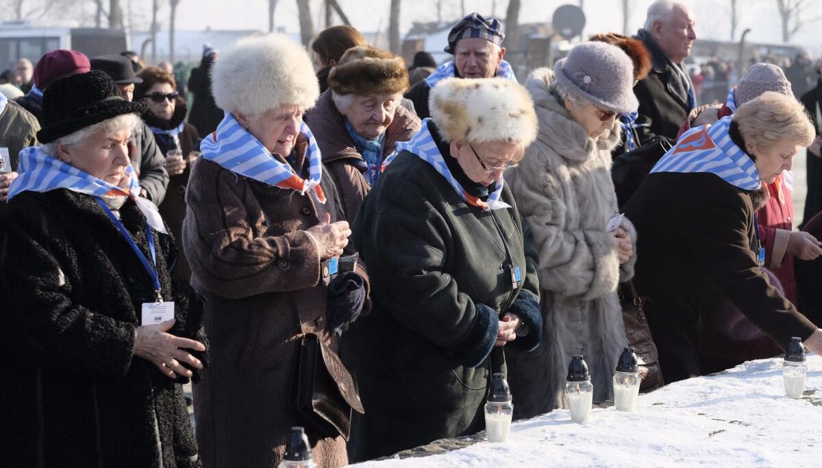 Former prisoners light candles at the International Monument to the Victims of Fascism after a ceremony marking the 72nd anniversary of the liberation of Auschwitz-Birkenau, in Oswiecim, Poland, on Friday.