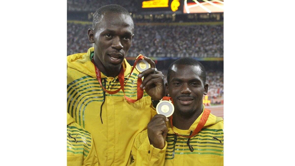 Usain Bolt, left, and Nesta Carter show their gold medals at the 2008 Beijing Olympics.