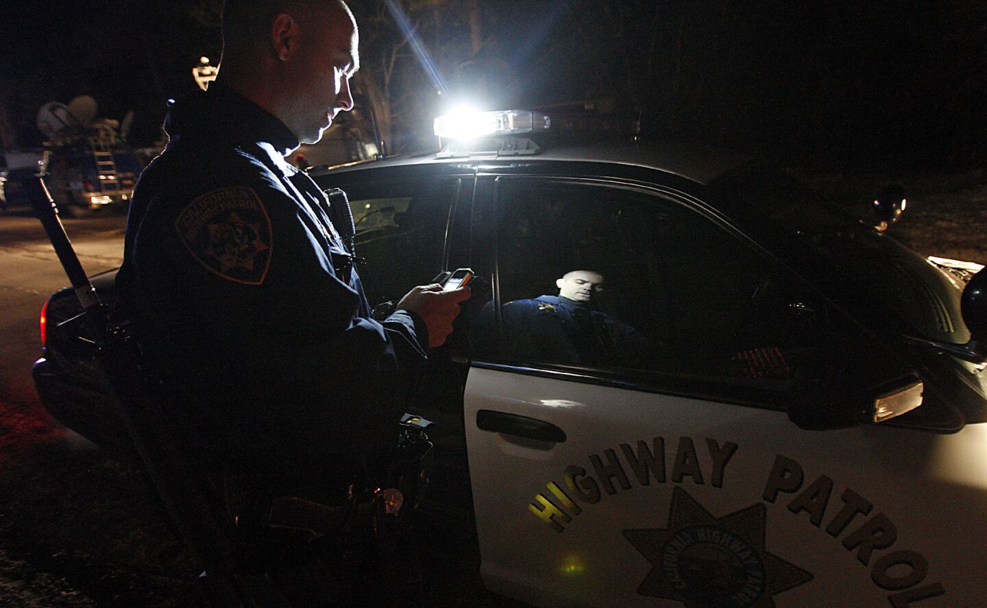 A California Highway Patrolman at checkpoint along Highway 38 near Big Bear. Roads are still closed in the area around the cabin.