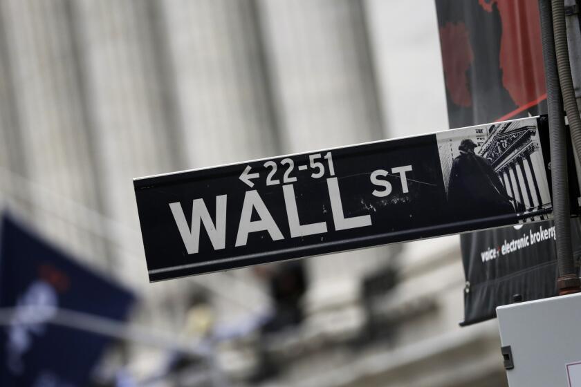 A Wall Street sign stands outside the New York Stock Exchange on Oct. 2, 2014.