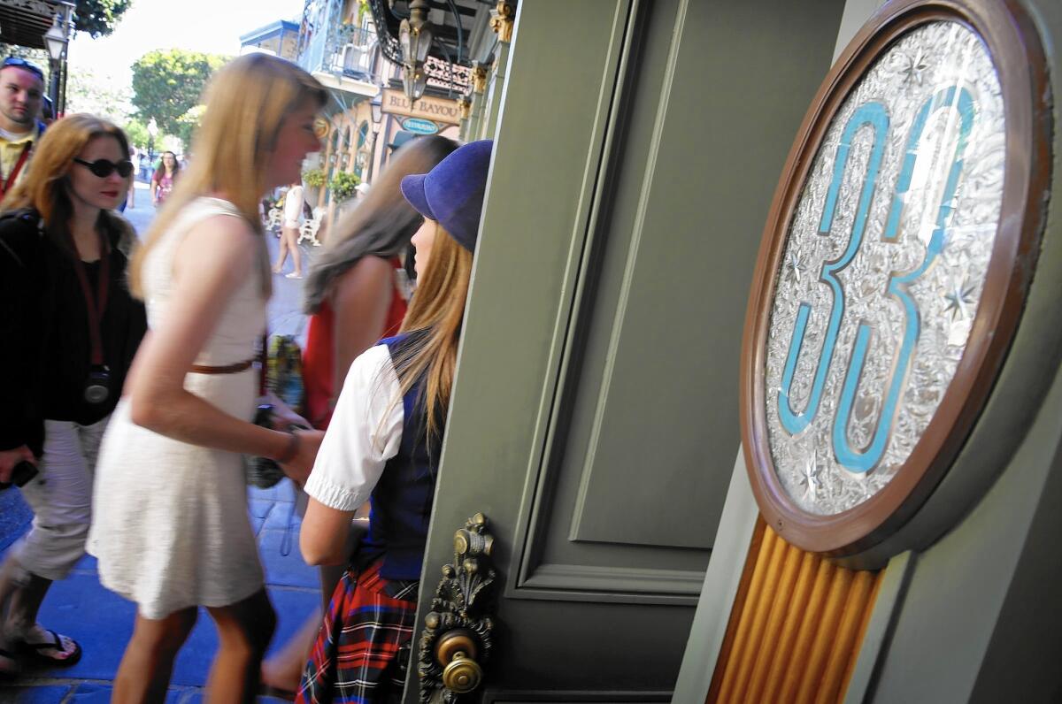 Victoria Dale, guest relations guide, holds open the door to the Club 33 restaurant for visitors on a special paid VIP tour at Disneyland in 2013.