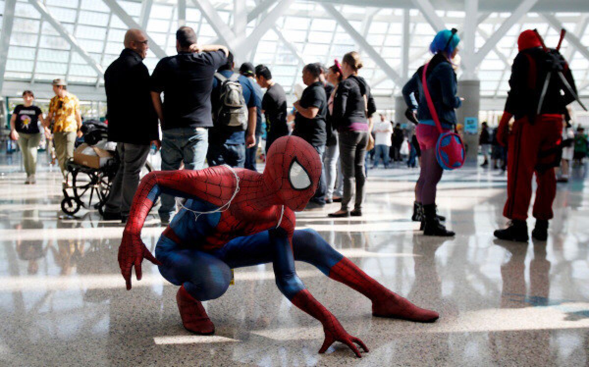 A person dressed as Spider-Man poses in a crowd