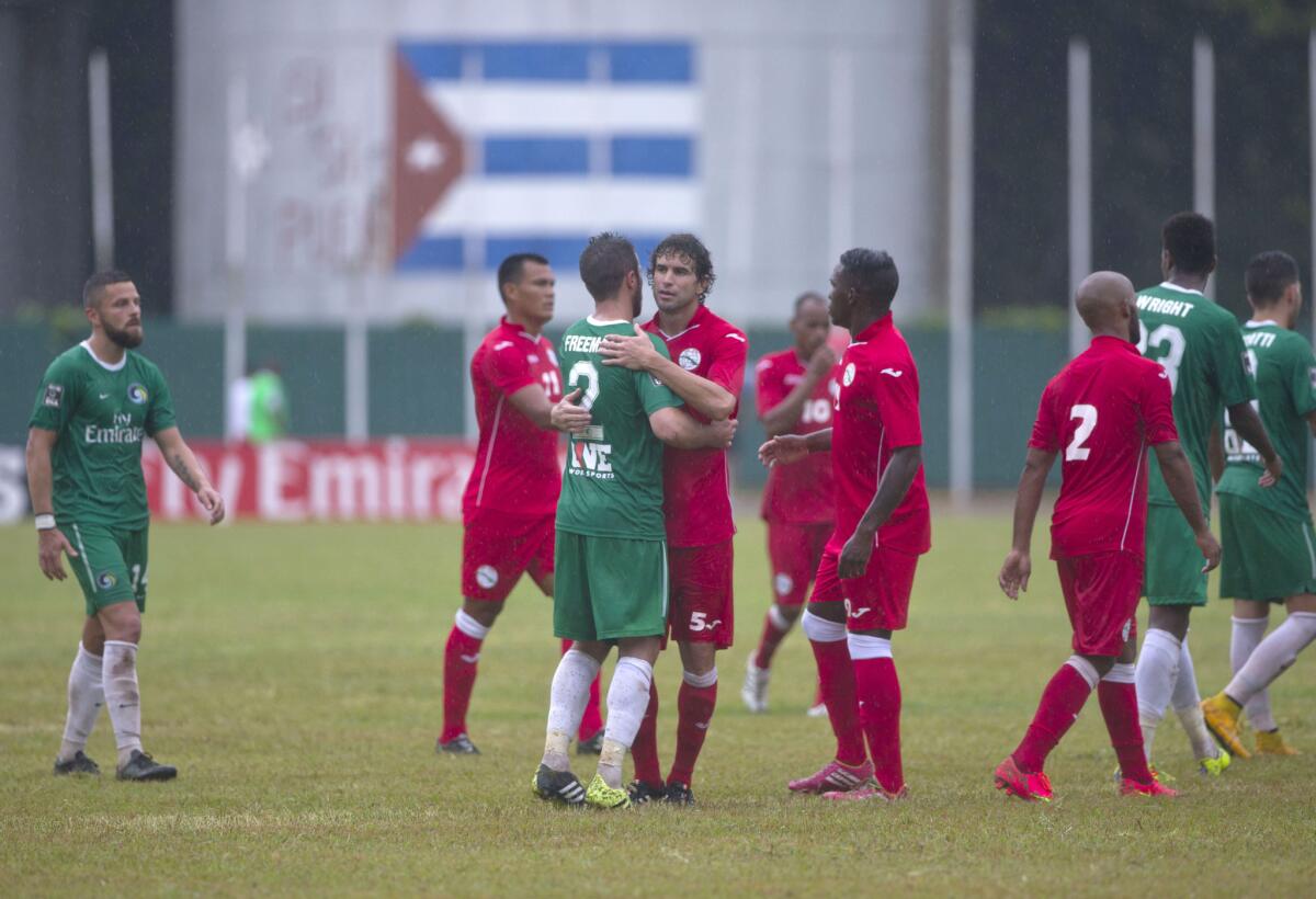 Jugadores del Cosmos de Nueva York y Cuba se abrazan al final del partido.