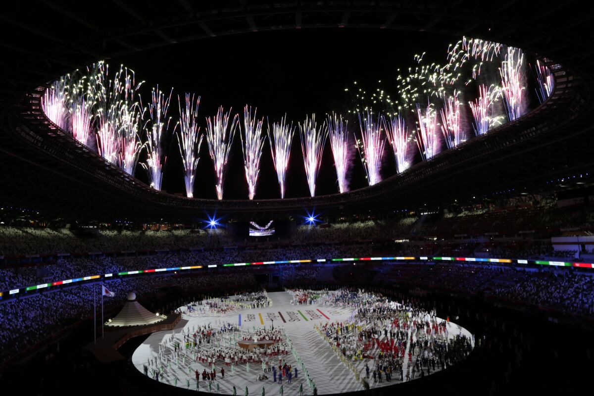 The Tokyo Olympics opening ceremony is illuminated by fireworks.