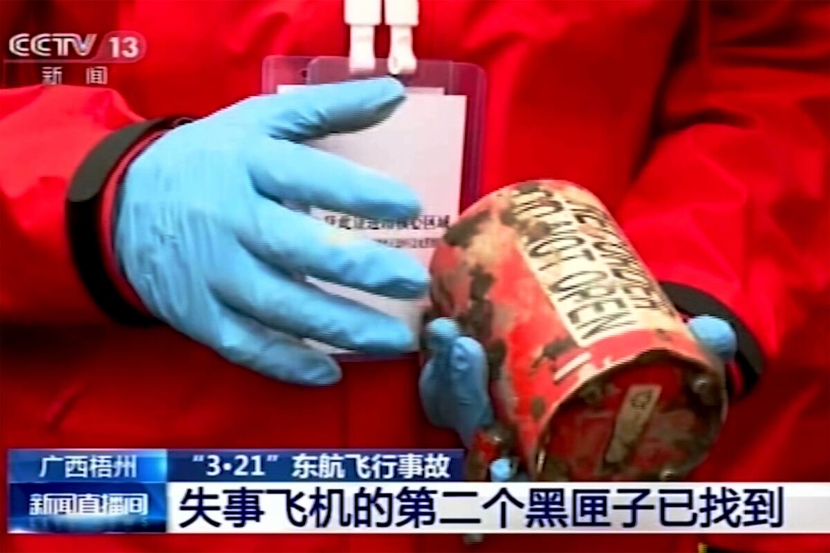 A rescue worker holds an orange-colored "black box" recorder