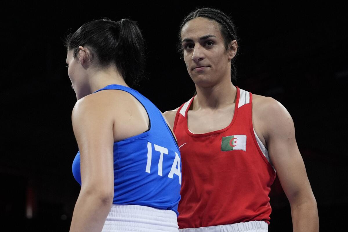 Algeria's Imane Khelif, right, walks beside Italy's Angela Carini after their women's 66 kilogram preliminary boxing match.