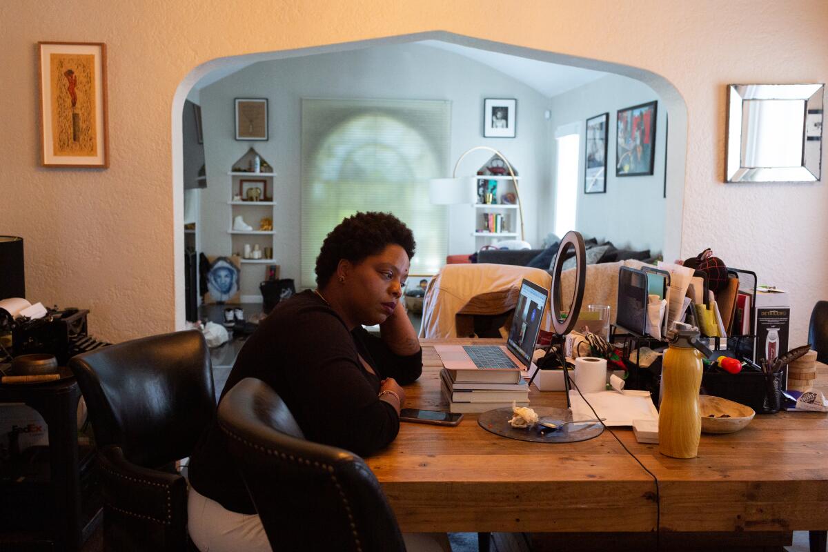 Patrisse Cullors takes a Zoom call at her dining room table.