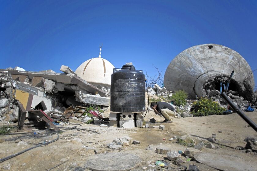 A Palestinian man prays next to the rubble of a mosque in the Khan Younis district. More than 100,000 homes across Gaza were destroyed or badly damaged in the fighting between Israel and Hamas.